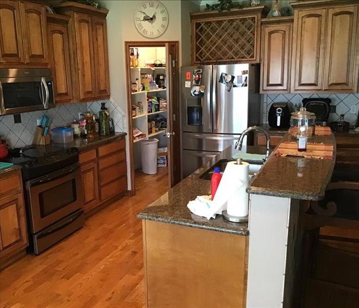 kitchen cabinets and wood floors flooded with water