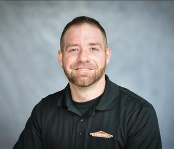 male employee with red hair in front of green background