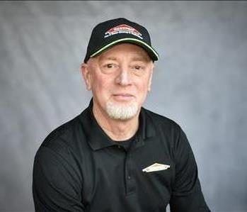 male employee standing in front of green background